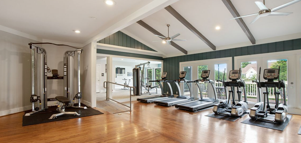 the home gym has plenty of exercise equipment and windows