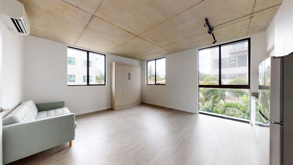 an empty living room with a couch and a window