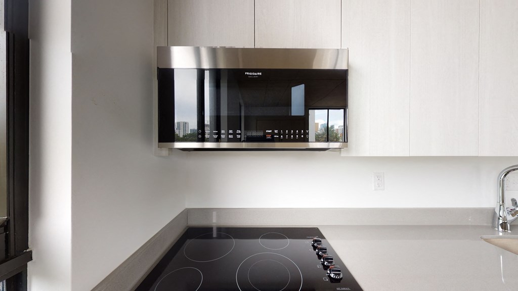 a kitchen with a black stove and a microwave above it