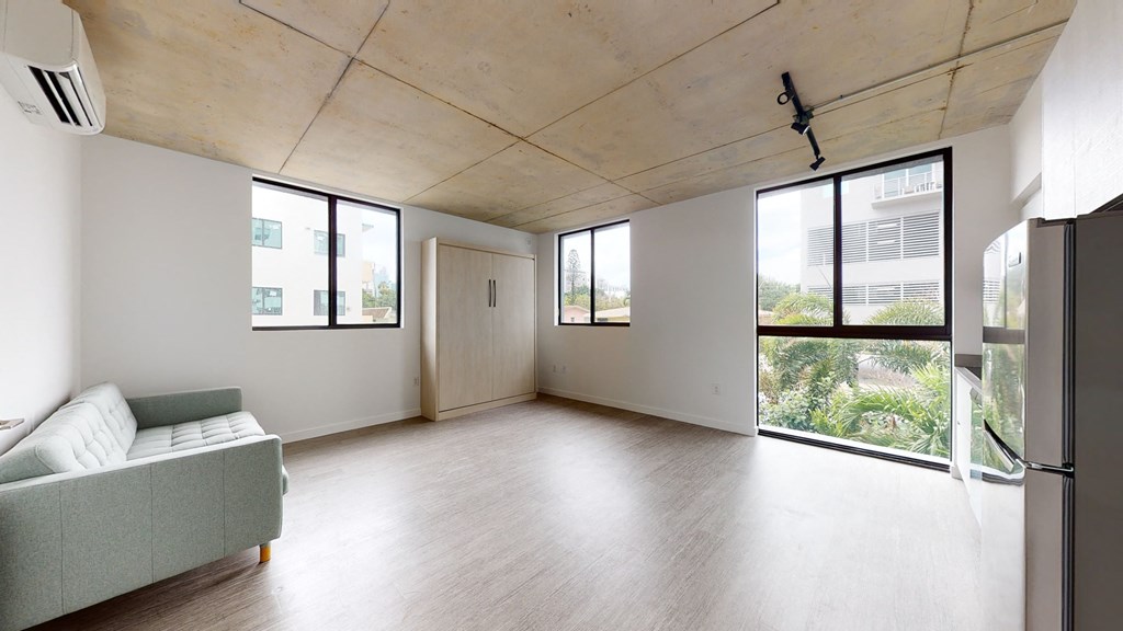 an empty living room with a couch and a window