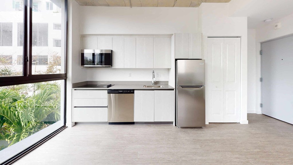 a kitchen with white cabinets and a stainless steel refrigerator