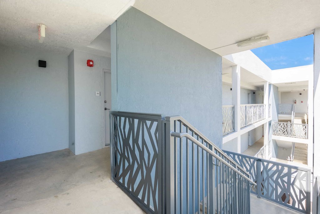 a balcony with a railing and a building in the background