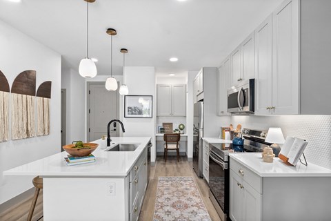 a white kitchen with white counters and white appliances and white cabinets