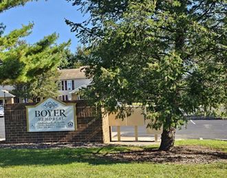 a tree in front of a building with a sign