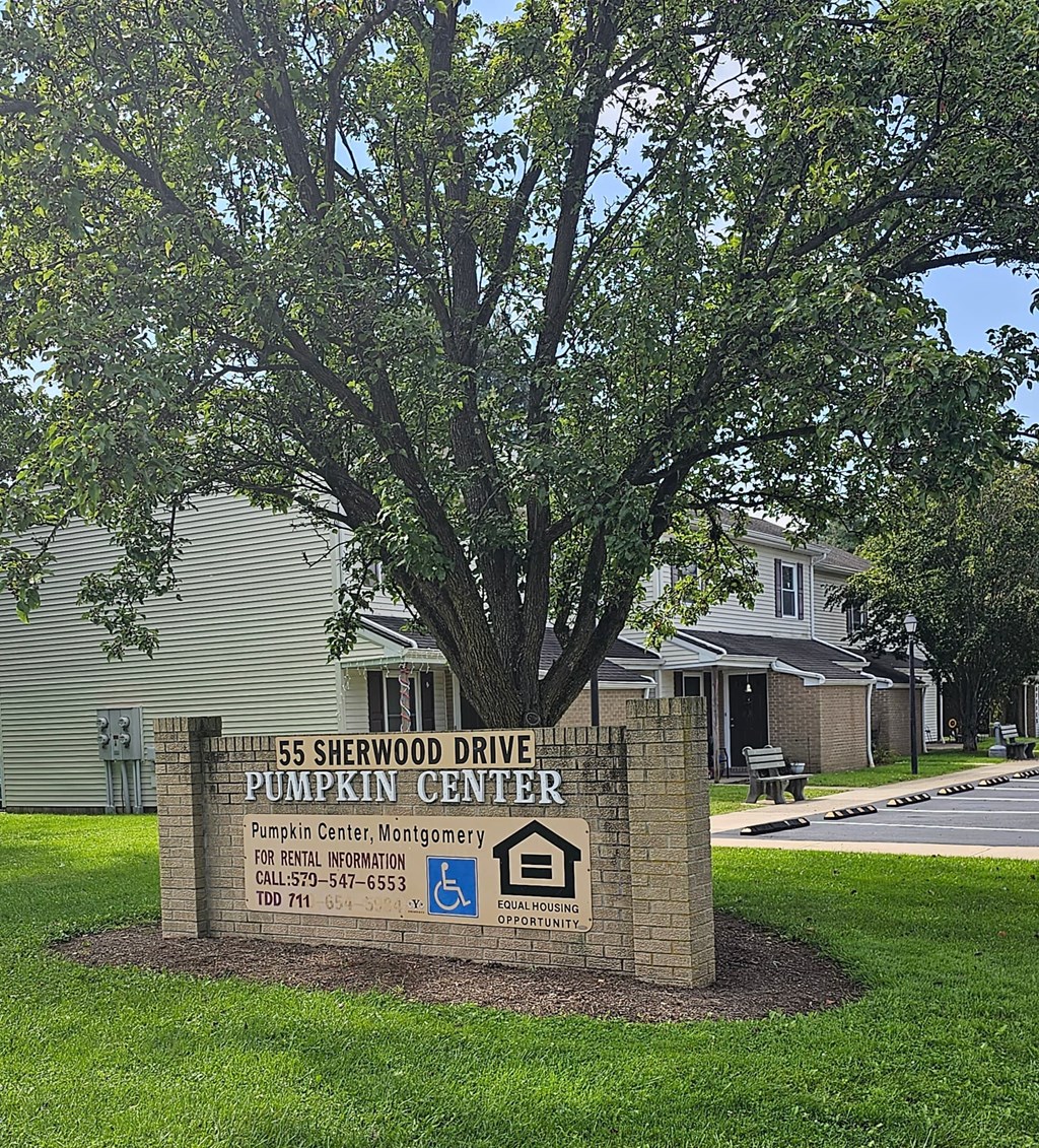 a sign for the is sherwood drive pumpkin center in front of a tree