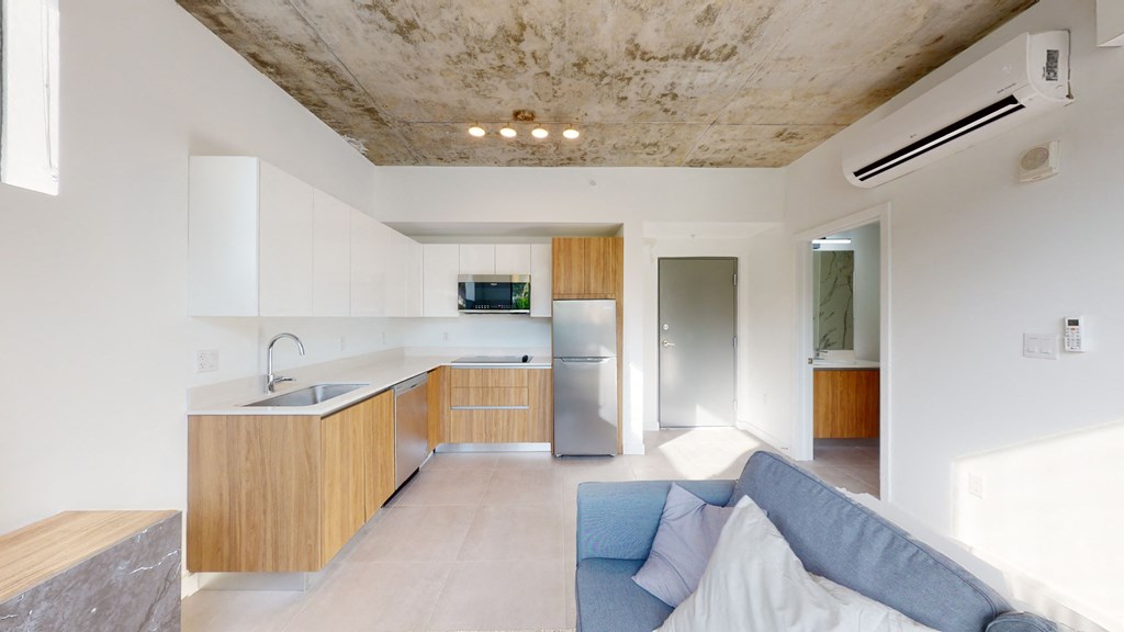 a living room with a couch and a kitchen with a sink