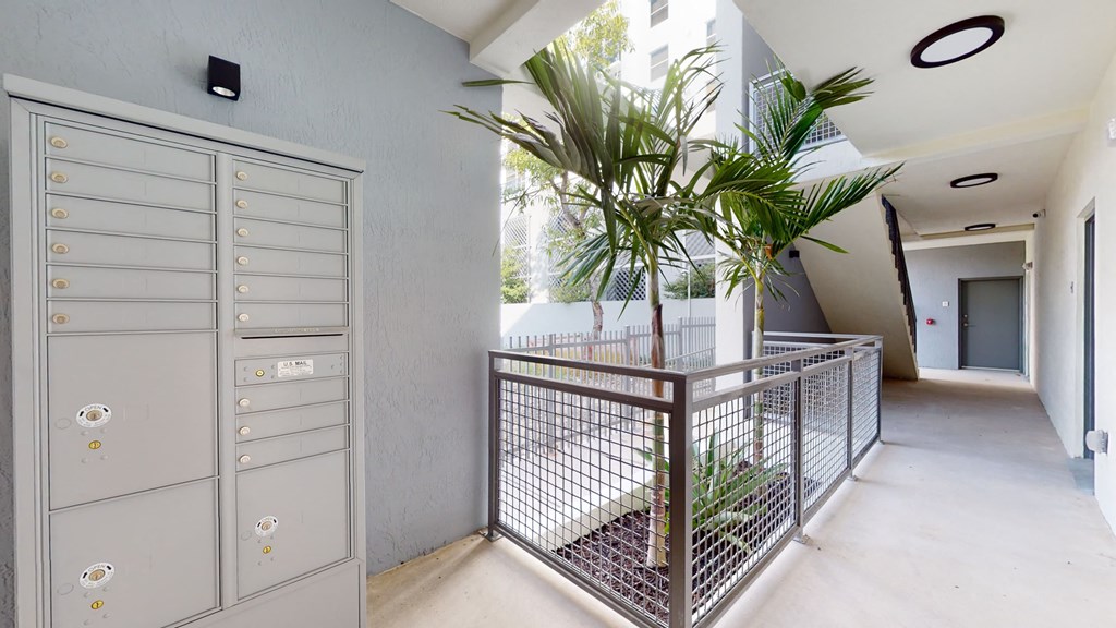 a long hallway with a staircase and a plant in the middle