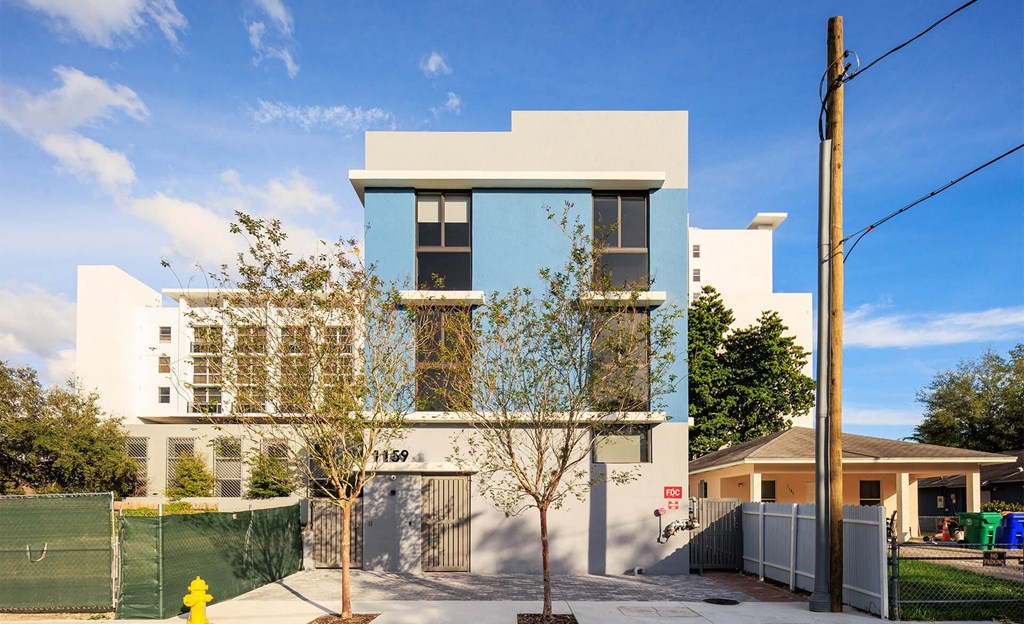 the exterior of a house with blue and white facade and a fence
