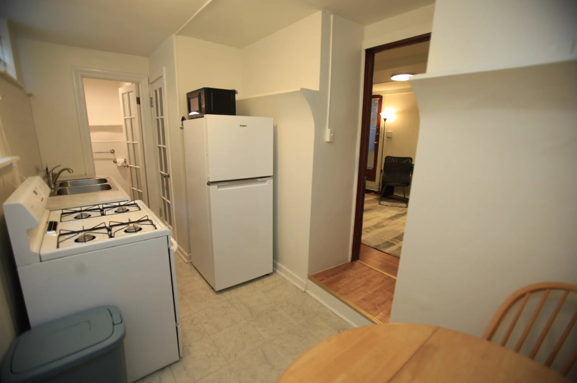 a kitchen with a stove and refrigerator and a dining room table