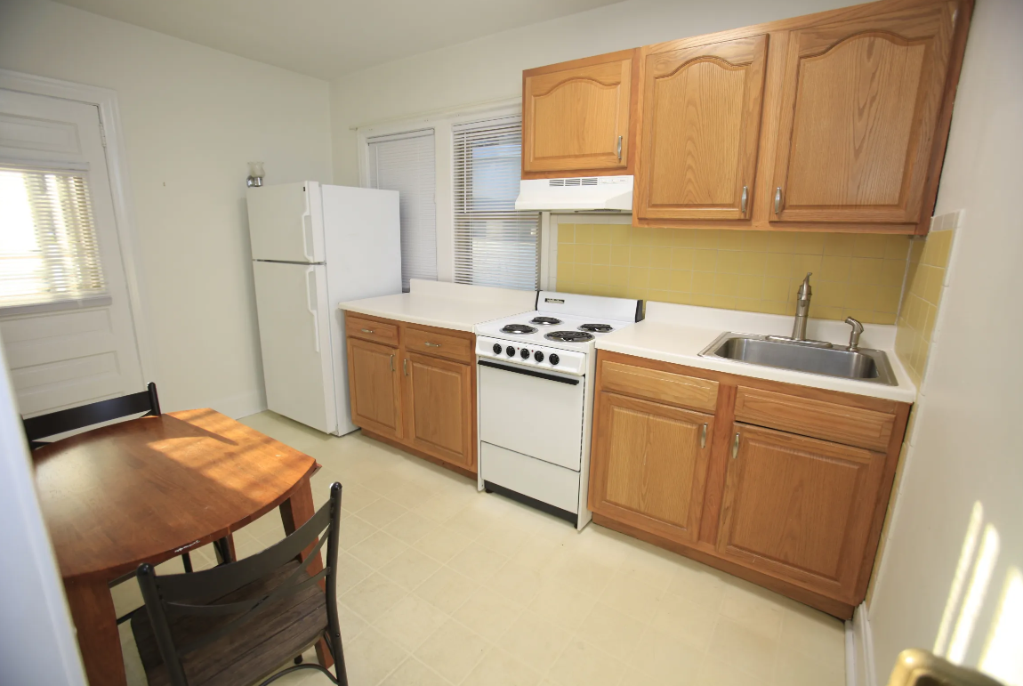 a kitchen with a table and a stove and a refrigerator