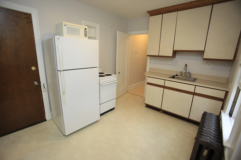a kitchen with a refrigerator and a sink and