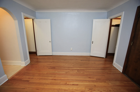 a empty room with blue walls and wooden floors