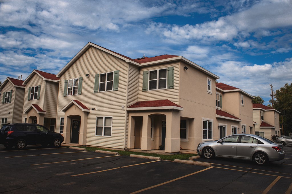 an apartment building with cars parked in front of it