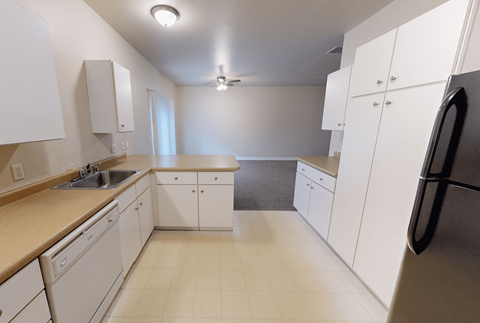 A kitchen with white cabinets and appliances.
