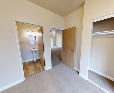 A room with a carpeted floor and a white table in the corner.