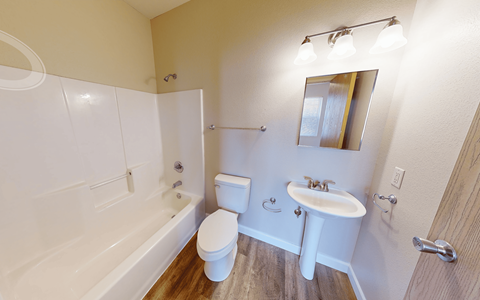 A white bathroom with a toilet, sink, and bathtub.