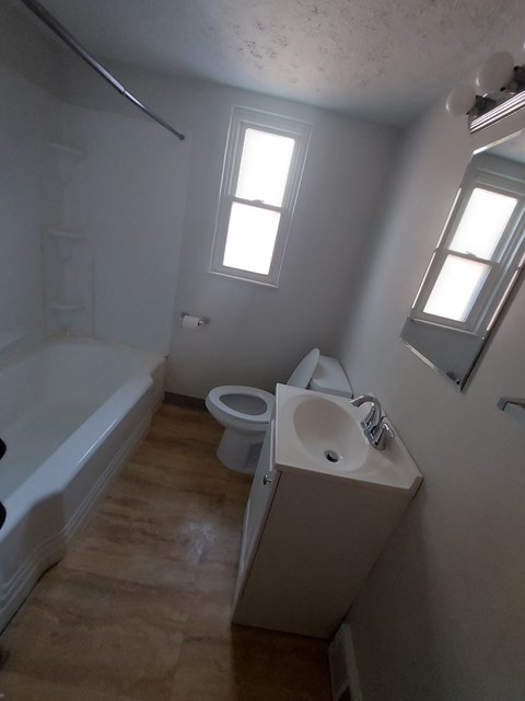 A bathroom with a toilet, sink, and bathtub.