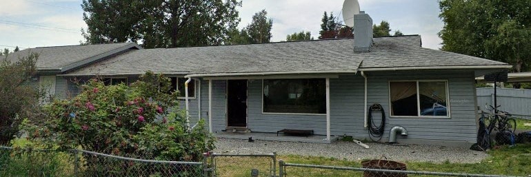 a gray house with a yard and a fence