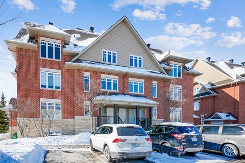 a large brick house with cars parked in front of it