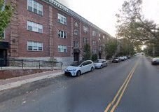a street with cars parked in front of a brick building