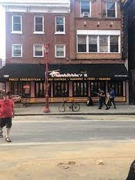 a man walking down a street in front of a restaurant