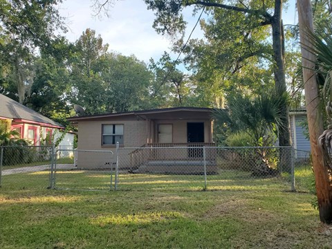 a small house with a fence in front of it