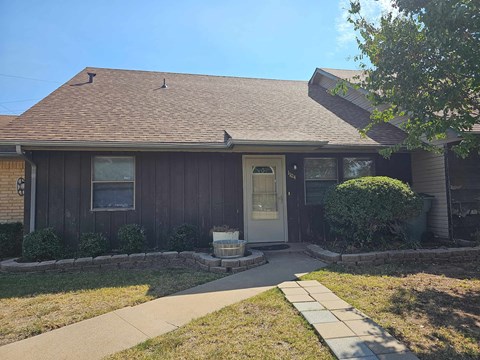 a brown house with a sidewalk in front of it