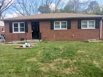 a brick house with a yard and a front porch