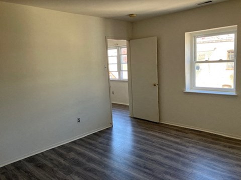 a living room with white walls and a wood floor