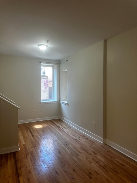 a living room with wood floors and a window