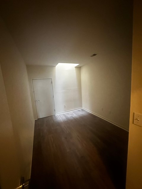 an empty room with a wooden floor and a door