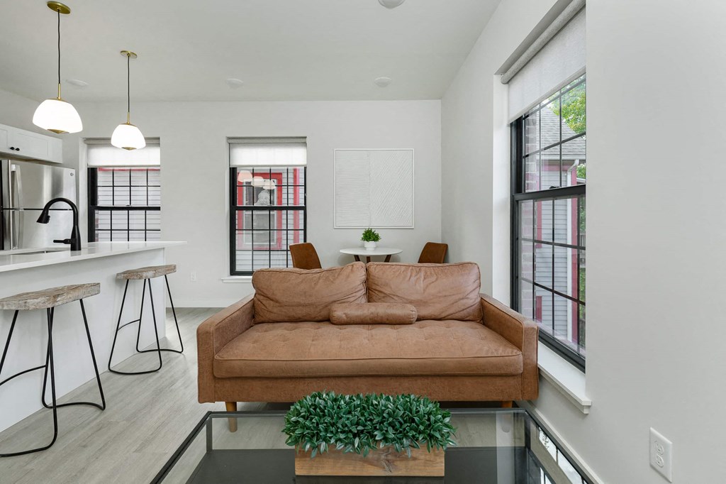 a living room with a couch and a kitchen with a table