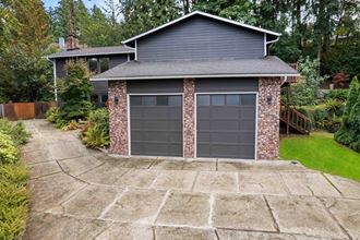 a garage door on a brick house with a stone driveway