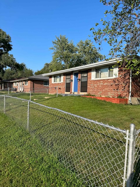 a house with a chain link fence in front of it