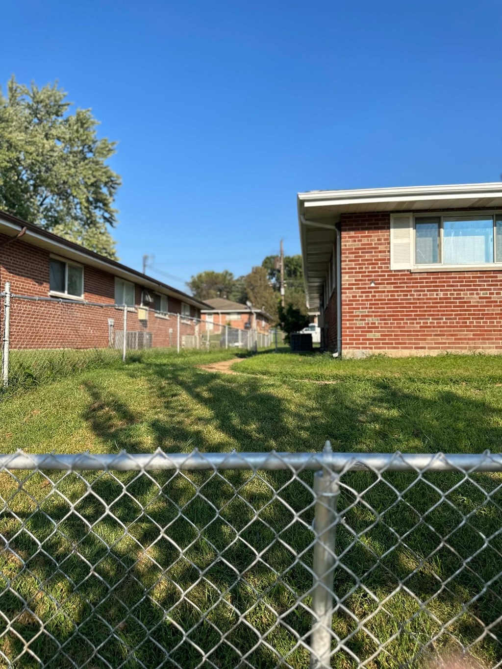 a chain link fence in front of a brick building