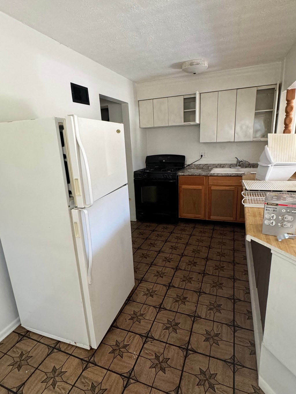 a kitchen with a white refrigerator and a black stove