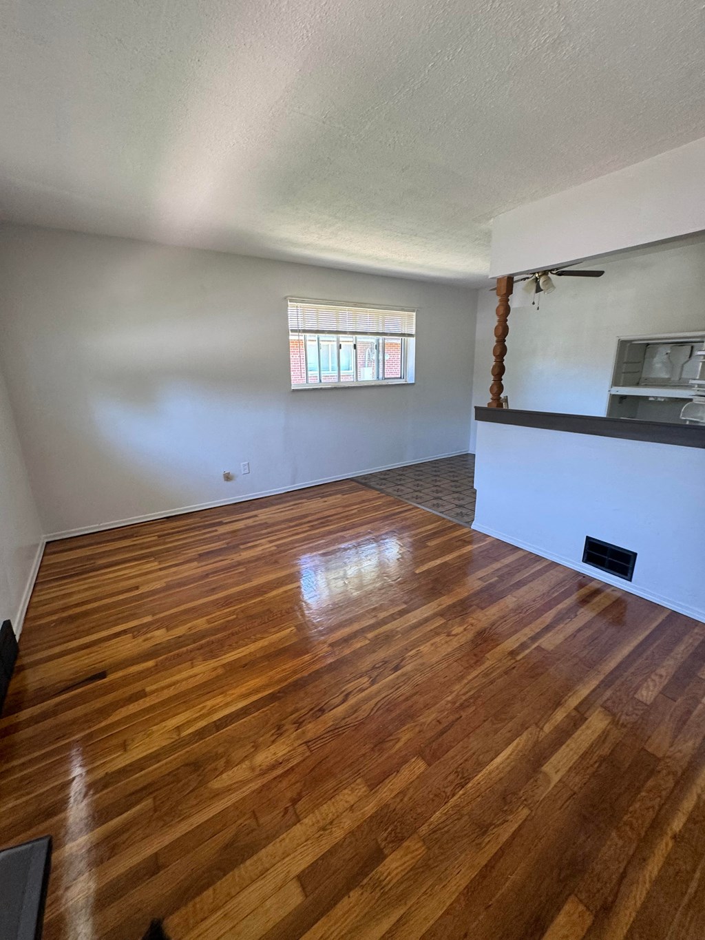 an empty living room with a hard wood floor