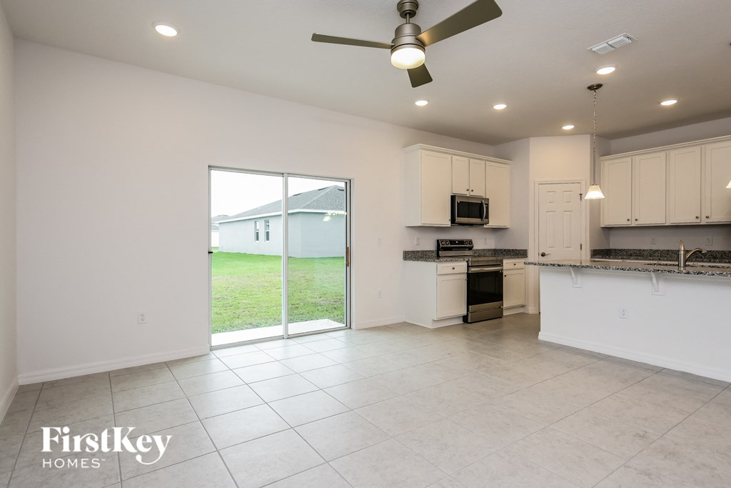 an empty kitchen with a sliding glass door to the backyard