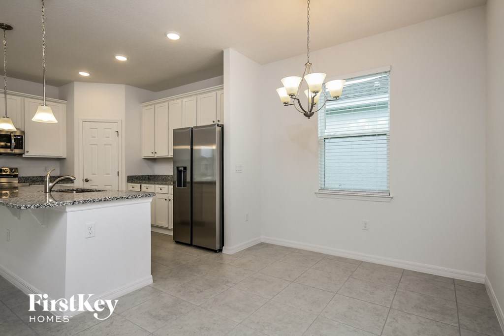 a kitchen with white cabinets and a stainless steel refrigerator