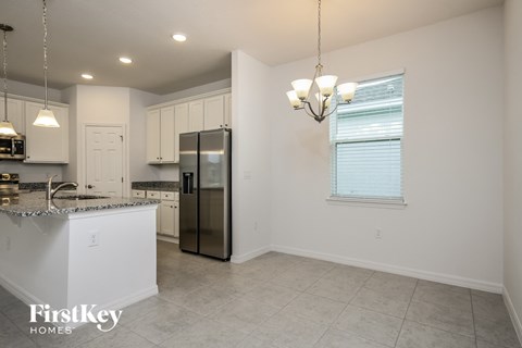 a kitchen with white cabinets and a stainless steel refrigerator
