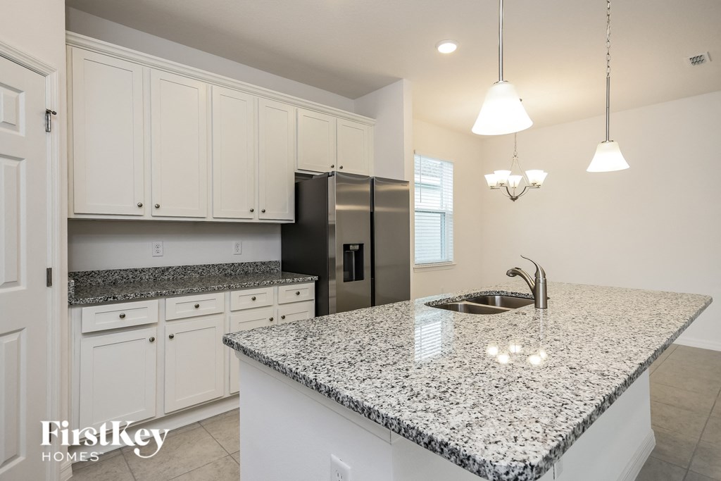 a kitchen with white cabinets and a granite counter top