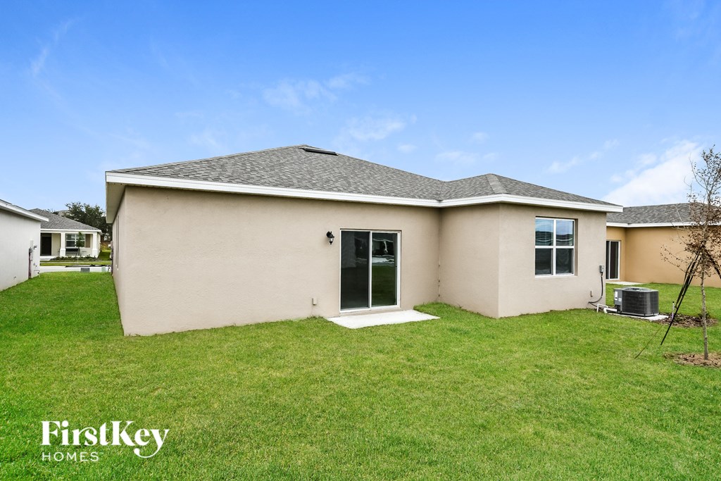 a beige house with a lawn and a backdoor