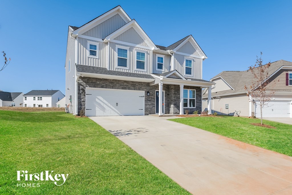 A large, modern house with a garage is showcased in the image.