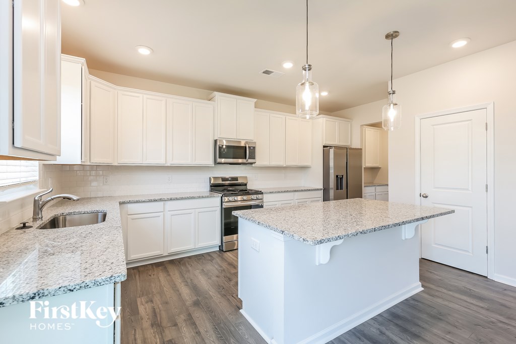 A kitchen with a granite countertop and white cabinets.