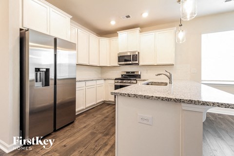 a kitchen with white cabinets and stainless steel refrigerator