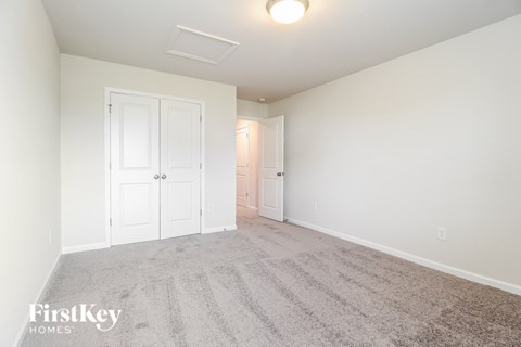 a bedroom with a carpeted floor and white doors