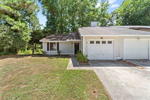 a white house with a garage and a lawn