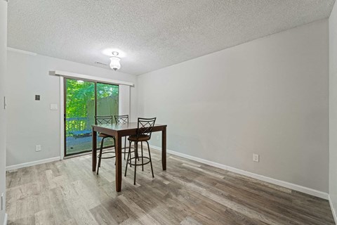 a dining room with a table and chairs next to a sliding glass door