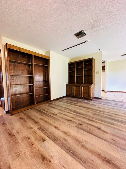 a living room with wooden floors and a closet with wooden doors