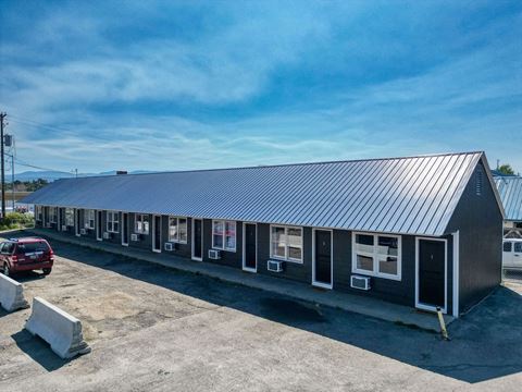 a building with a metal roof and a parking lot